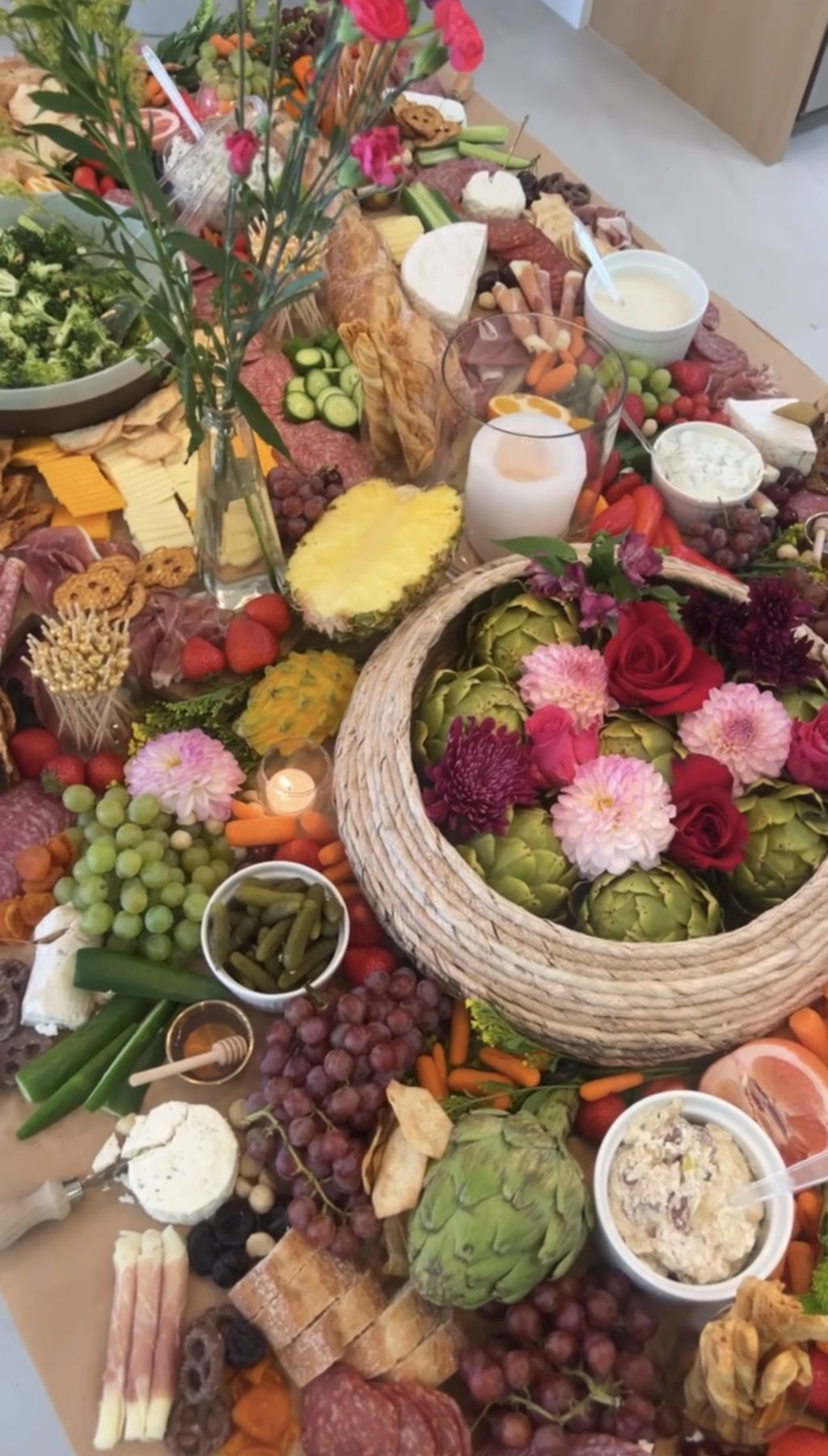 Elevated grazing table spread with charcuterie, cheese, fruit and florals